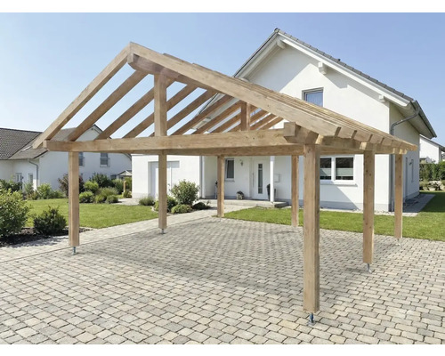 Holzcarport auf gepflasterter Fläche vor einem Wohnhaus.