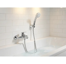 Badezimmer mit Badewanne, Armatur und Handbrause vor Wandfliesen