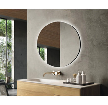 Modernes Badezimmer mit rundem Spiegel, Waschtisch und Armatur.