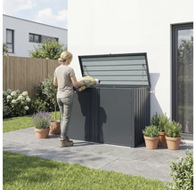 Frau befüllt eine Gartentruhe mit einem Sack Pflanzerde im Garten.