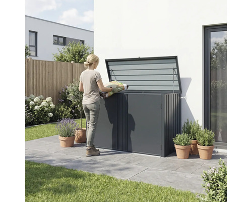 Frau befüllt eine Gartentruhe mit einem Sack Pflanzerde im Garten.