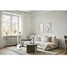 Heller Wohnraum mit Sofa, Tisch und Turmventilator