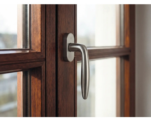 Detailansicht eines Fensters mit Holzrahmen und Fenstergriff