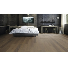 Schlafzimmer mit Bett, Nachttisch, Schreibtisch und Holzboden