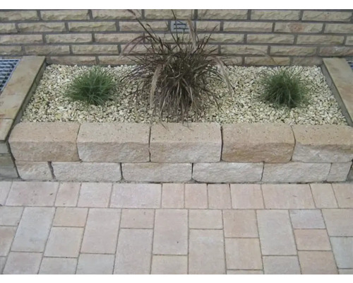 Hochbeet mit Pflanzen und Steinen im Garten