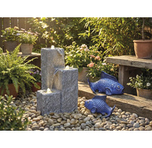 Gartenszene mit Kaskadenbrunnen, Zierfischen und Pflanzen