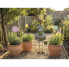 Gartenszene mit bepflanzten Terrakottatöpfen, Blumensteckern und einer Gartendekoration in Hasenform