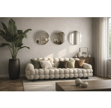 Wohnzimmer mit Sofa, Kissen, runden Spiegeln und Zimmerpflanze