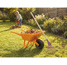 Garten Szene mit Schubkarre, Rechen und Kind beim Laubsammeln