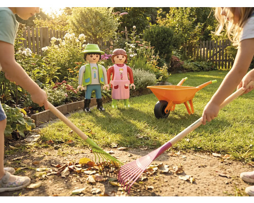 Szene mit Kindern, die mit Rechen Blätter im Garten zusammenkehren, sowie Playmobil Figuren und Schubkarre