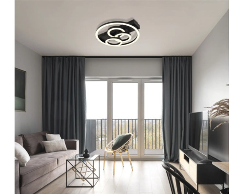 Wohnzimmer mit moderner Deckenleuchte, Sofa und Fenstern