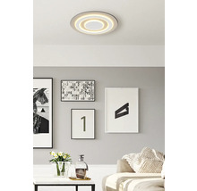 Moderne Wohnraumgestaltung mit runder Deckenleuchte und dekorativen Bildern an der Wand