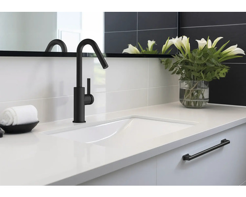 Waschbecken mit schwarzer Armatur, Handtuch und Blumenvase im Badezimmer