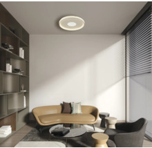 Wohnzimmer mit Sofa, Sessel, Tisch und runder Deckenleuchte