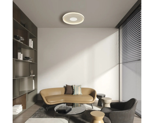 Wohnzimmer mit Sofa, Sessel, Tisch und runder Deckenleuchte