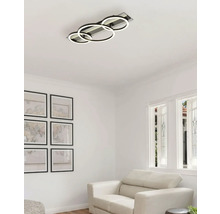 Deckenleuchte mit drei LED Ringen in einem hellen Wohnzimmer.
