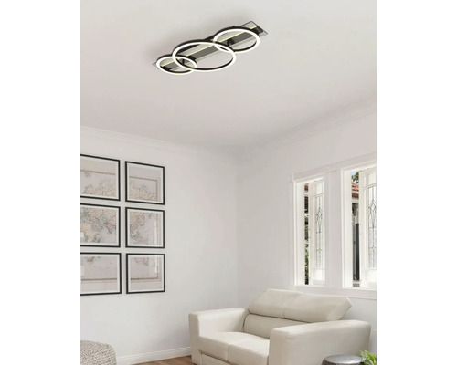 Deckenleuchte mit drei LED Ringen in einem hellen Wohnzimmer.