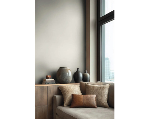 Wohnzimmer mit Sofa, Kissen und dekorativen Vasen auf einem Sideboard
