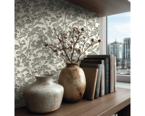 Vliestapete mit Baum-Muster im Skizzenstil an einer Wand hinter einem Holzregal mit Keramikvasen und Büchern in einem hellen Zimmer.