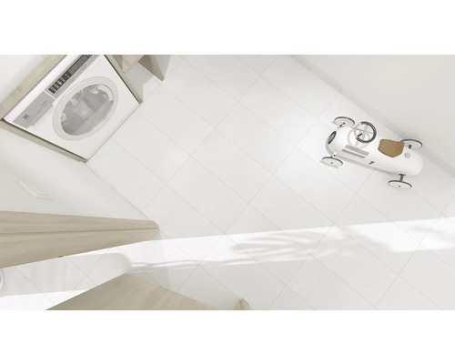 Waschmaschine, weiße Fliesen und ein Spielzeugauto im Badezimmer