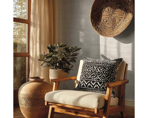 Dekoratives Interieur mit einem Stuhl, einem Kissen mit geometrischem Muster, einer großen Vase und einer Zimmerpflanze.