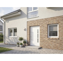 Ansicht eines Hauses mit weißer Haustür, Fenstern und Fassade mit Backsteinelementen