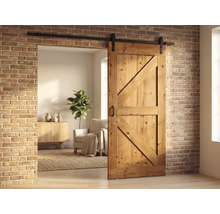 Holzschiebetür im Scheunenstil mit schwarzer Laufschiene vor einer Ziegelwand