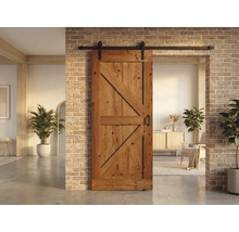 Holzschiebetür mit Beschlägen vor einer Ziegelwand