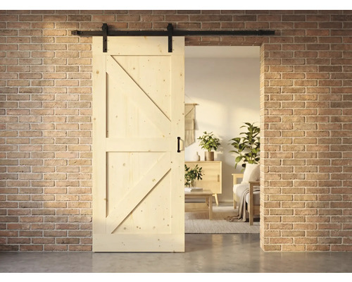 Holzschiebetür im Landhausstil mit Beschlägen vor einer Ziegelwand