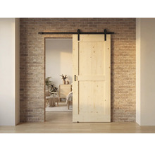 Holzschiebetür vor einer Ziegelwand, teilweise geöffnet und mit schwarzer Schiene