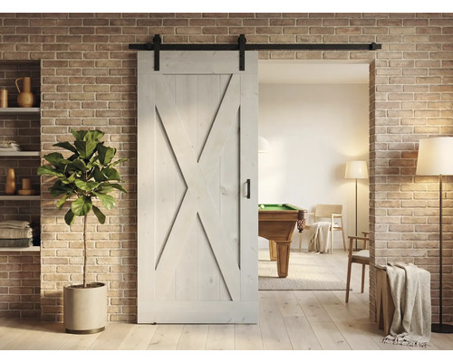 Holzschiebetür im Scheunenstil mit Beschlägen vor Ziegelwand