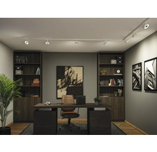 Modernes, organisiertes Arbeitszimmer mit weißem Schienensystem an der Decke, dunklem Schreibtisch, Lederstuhl und hohen Regalen.