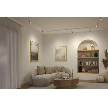 Helles modernes Wohnzimmer mit weißem Schienensystem und Strahlern, gebogenem Sofa, Holzcouchtisch und einem bogenförmigen Wandregal.