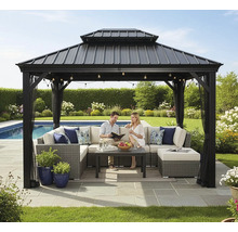 Gartenszene mit Pavillon, Sitzgruppe, Tisch, Pflanzen und zwei Personen