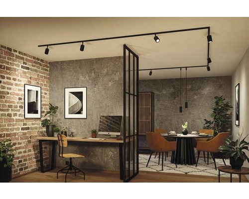 Moderner Wohnbereich mit Heimbüro und Esszimmer, getrennt durch eine Glastrennwand. Schwarzes Schienensystem an der Decke, Ziegel- und Betonwände.