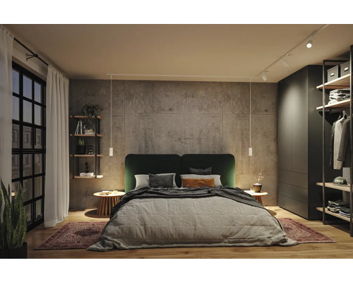 Modernes Schlafzimmer mit Doppelbett, dunkelgrünem Kopfteil, Wandpaneelen in Betonoptik, weißen Pendelleuchten, Schienensystem und Kleiderschrank.