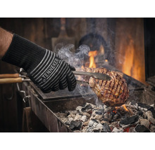 Grillhandschuh mit Fleisch auf dem Grill