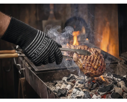 Grillhandschuh mit Fleisch auf dem Grill