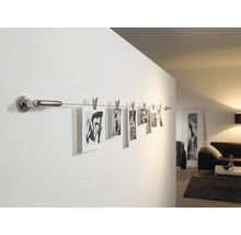 Fotos an einer Wandschiene mit Klammern im Wohnzimmer