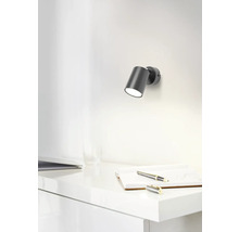 Szene mit einer Wandleuchte über einem Schreibtisch mit Notizbuch und Stift