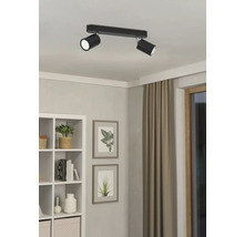 Schwarze Deckenleuchte mit zwei Strahlern in einem hellen Raum.