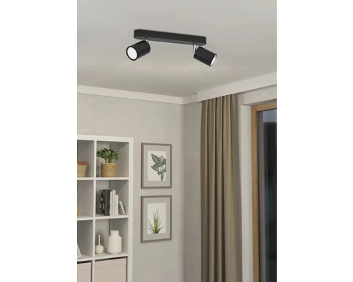 Schwarze Deckenleuchte mit zwei Strahlern in einem hellen Raum.
