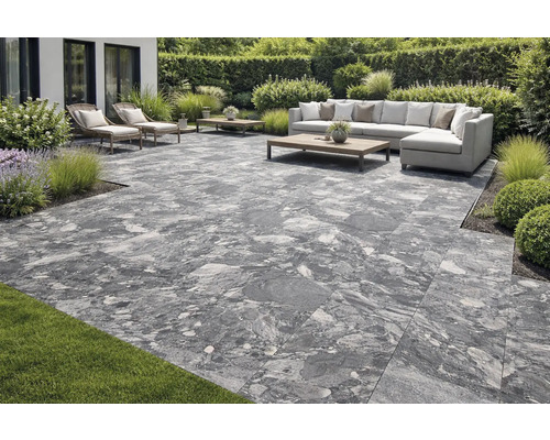 Terrasse mit grauen Terrassenplatten, Gartenmöbeln und Bepflanzung