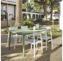 Grüner Gartentisch mit vier weißen Stühlen im Außenbereich.