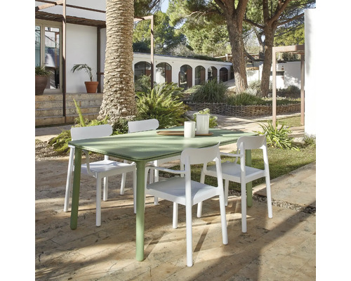 Grüner Gartentisch mit vier weißen Stühlen im Außenbereich.