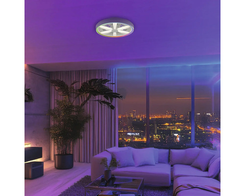 Modernes Wohnzimmer mit Deckenventilator inklusive Beleuchtung, Sofa, großem Fenster mit Stadtblick und Zimmerpflanzen.