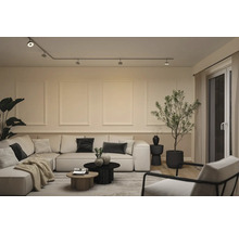 Modernes, helles Wohnzimmer mit Schienensystem-Beleuchtung, modularem Sofa, Couchtischen, Zimmerpflanzen und Wandgestaltung mit Zierleisten.