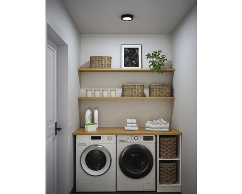 Moderner Hauswirtschaftsraum mit Waschmaschine, Trockner, Holzregalen und geflochtenen Körben in organisierter Anordnung.