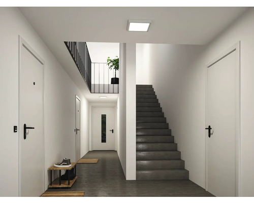 Moderner, heller Flur mit weißen Türen, einer dunklen Treppe und einer quadratischen LED-Deckenleuchte.