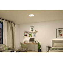 Quadratisches weißes LED-Panel an der Decke eines modern eingerichteten Zimmers mit Schreibtisch, Wandregalen und Bett.
